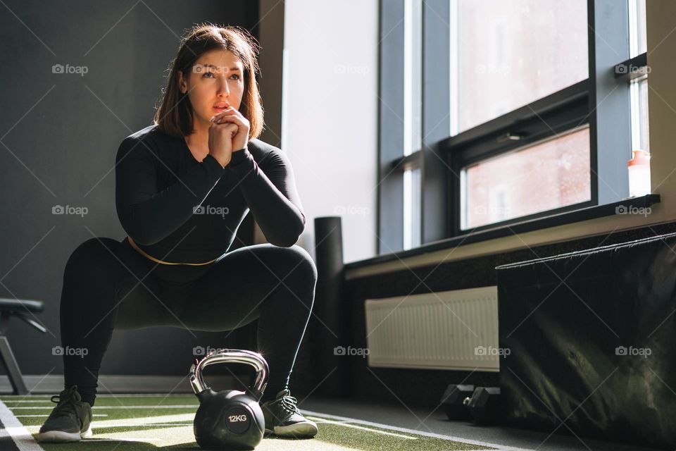 Young brunette woman training her muscles in the fitness club gym