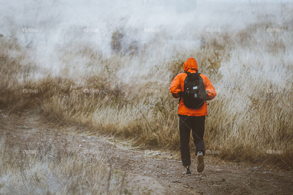 Man walking in road in cold mist weather