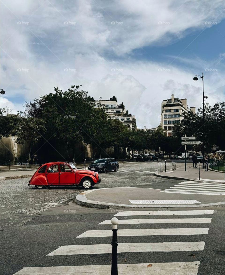 A bright red car driving through the streets of the city