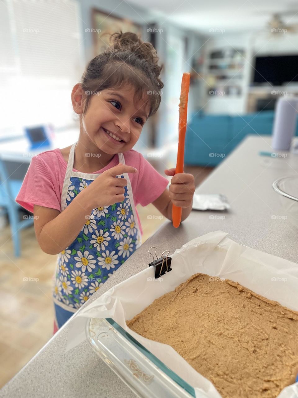 Little girl acts silly in the kitchen, acting silly with a spatula in the kitchen, baking treats in the kitchen, baking with mommy in the kitchen 