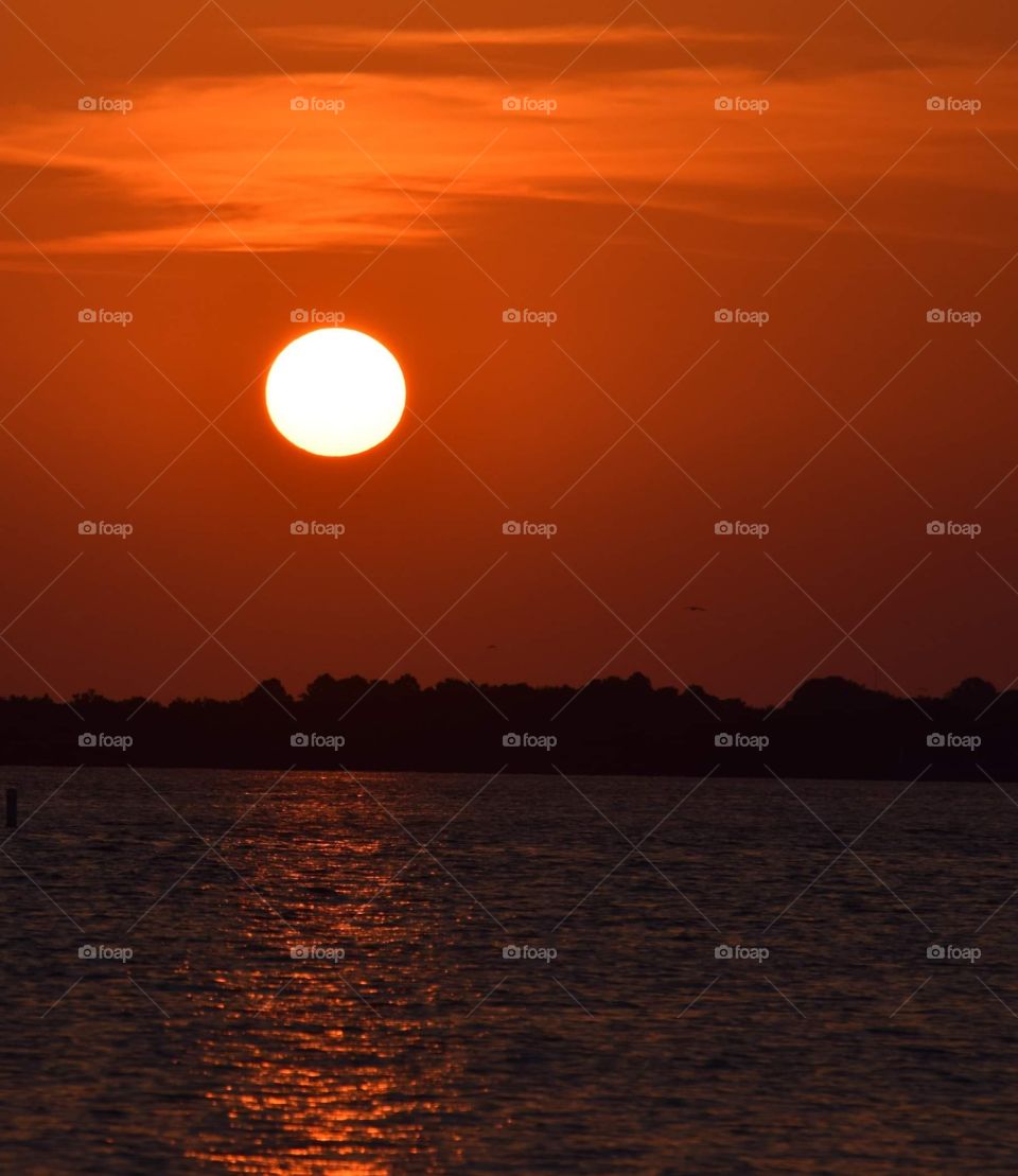 Red light from this amazing sunset over the water is spectacular