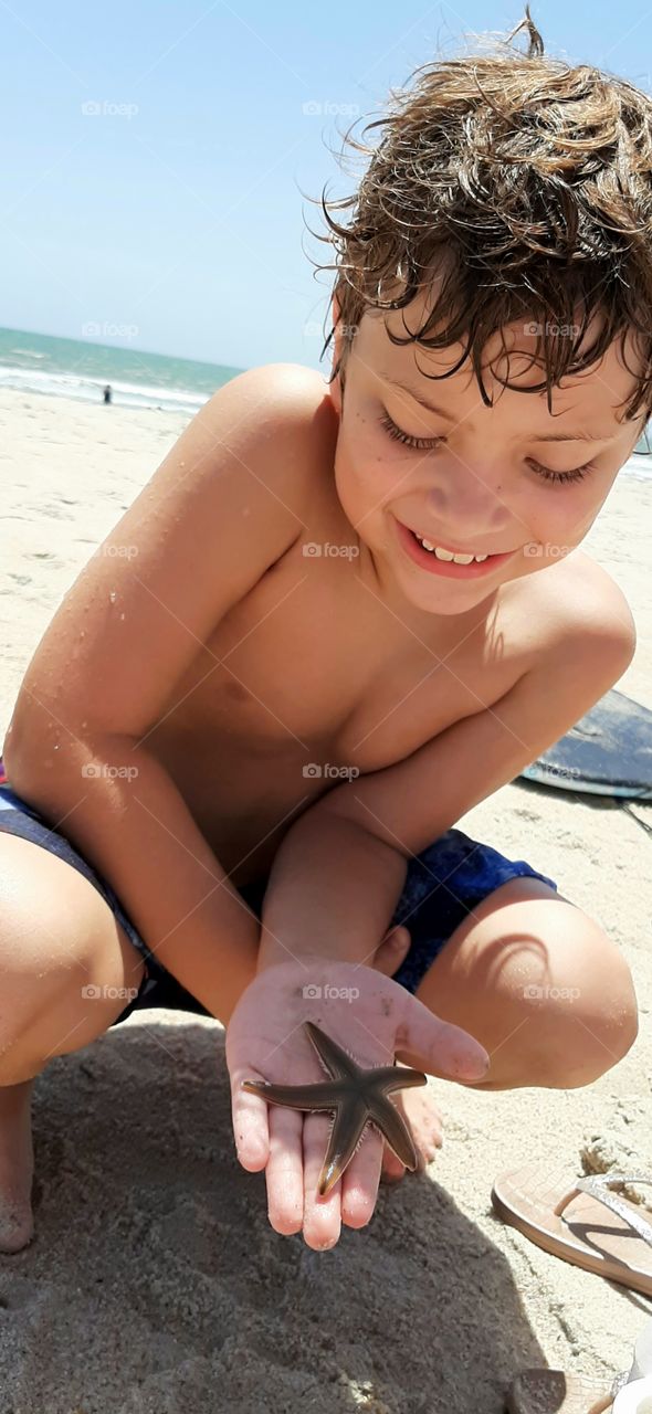 finding a starfish on the beach! it was still alive so he returned it to the ocean