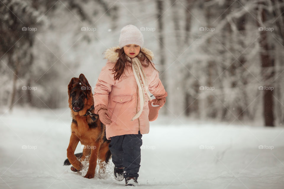 Portrait of beautiful Little girl and puppy at winter forest