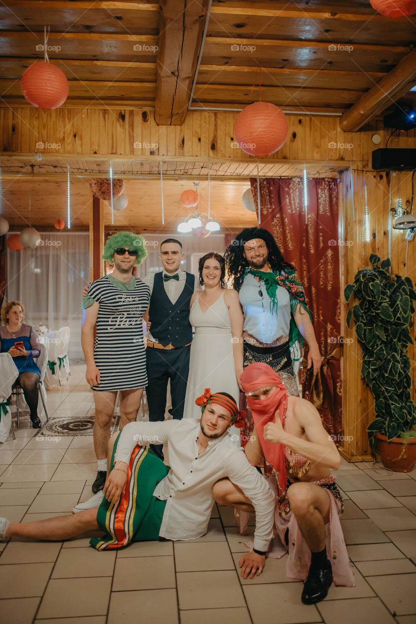 Photo of bride and groom with friends dressed in costumes