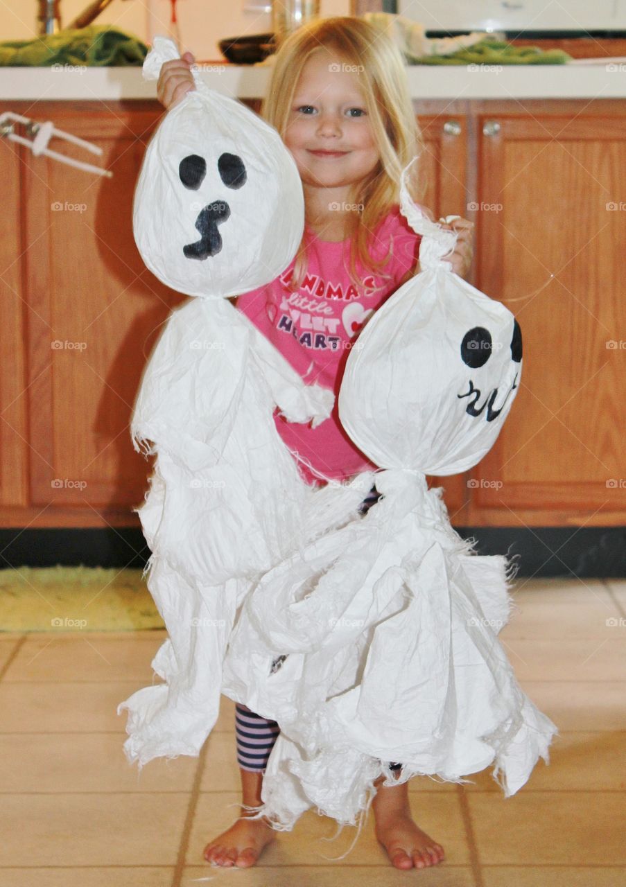 little girl with homemade ghost Halloween decorations