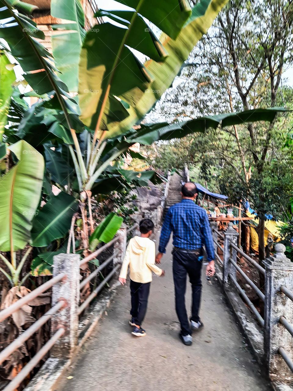 Dad and Son walking along the ancient bridge pathway