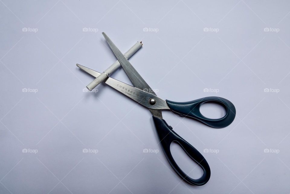 New Year's resolutions to quit smoking. Cigarette in scissors.
