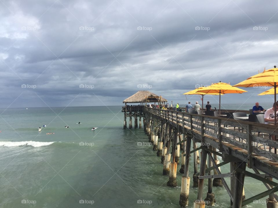 Fishing Pier with bungalow and yellow umbrellas 