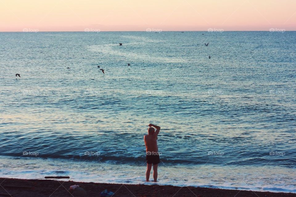 Man alone at the sunrise beach 