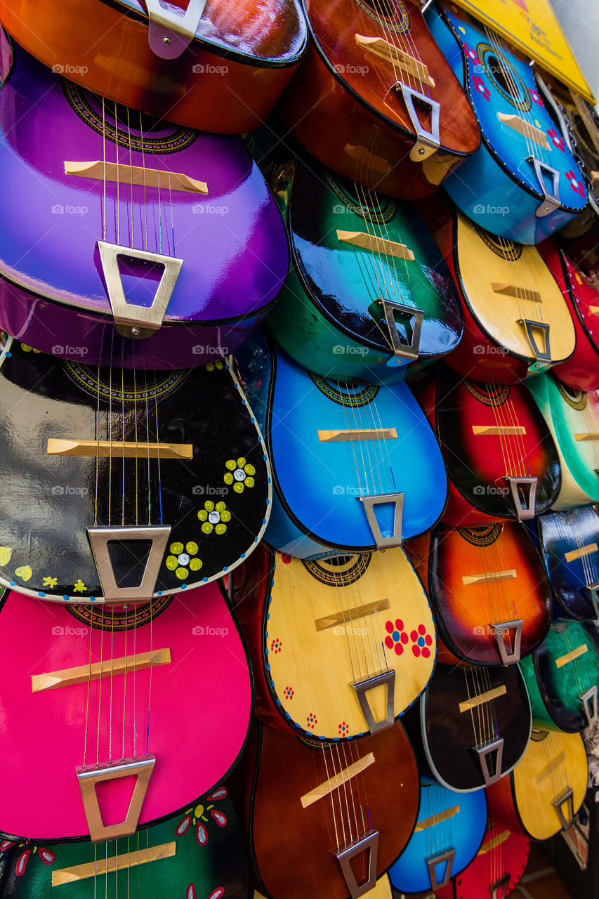 Colorful decorated ukuleles, small guitars, hand waiting for sale at a market stall in Downtown LA. 