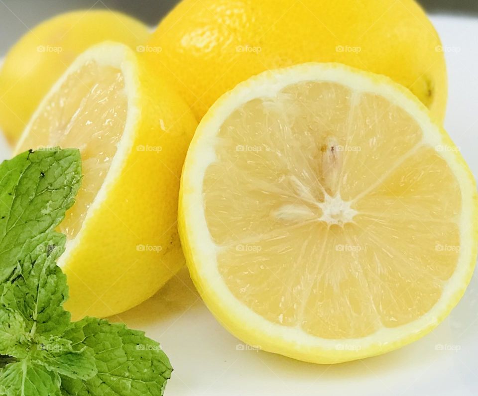 Everyone likes to drink lemonade in summer time,so here a two peace’s of lemon and mint leaves arranged in white plate.