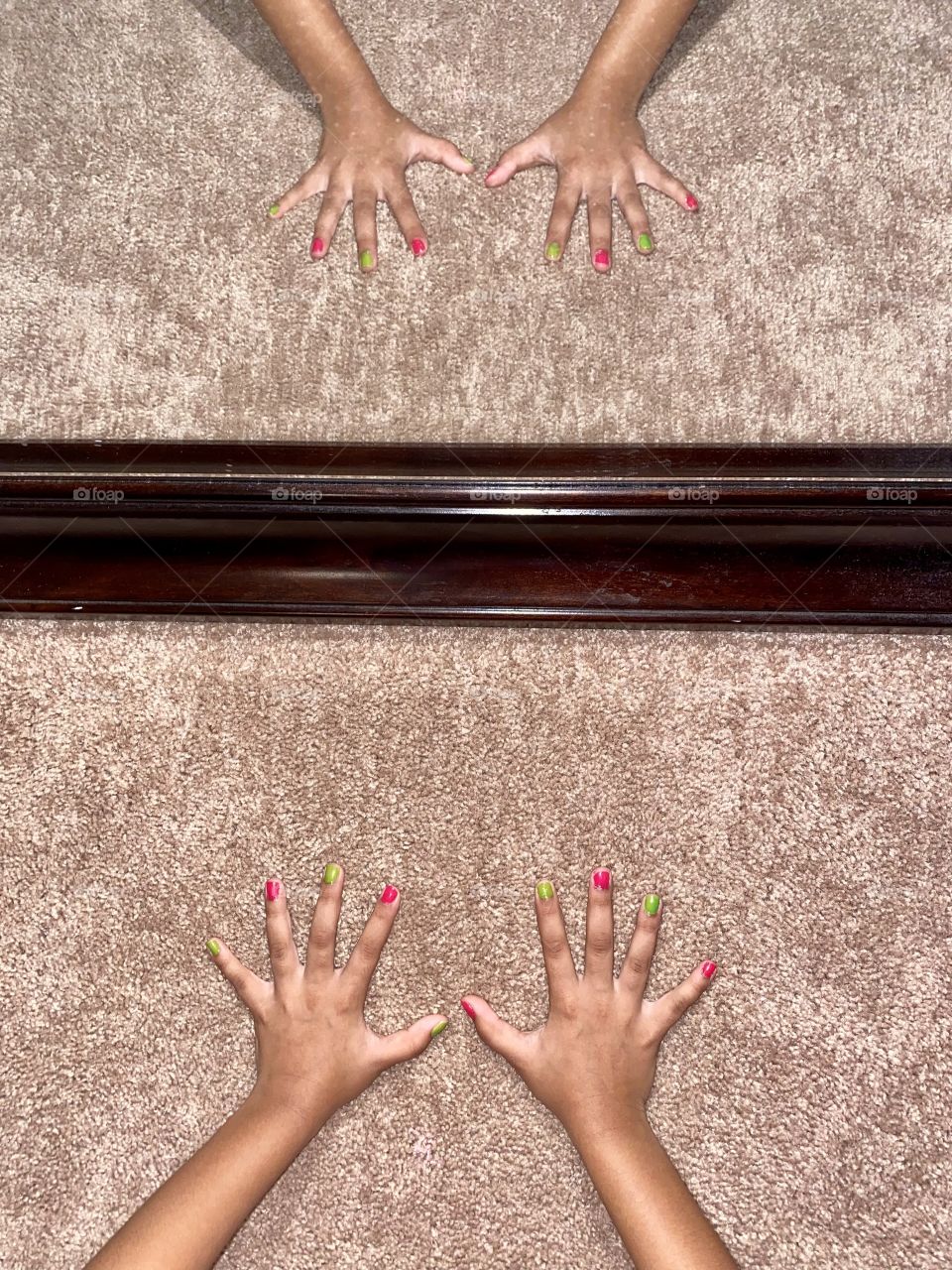 Reflection of little manicured hands with watermelon colors 