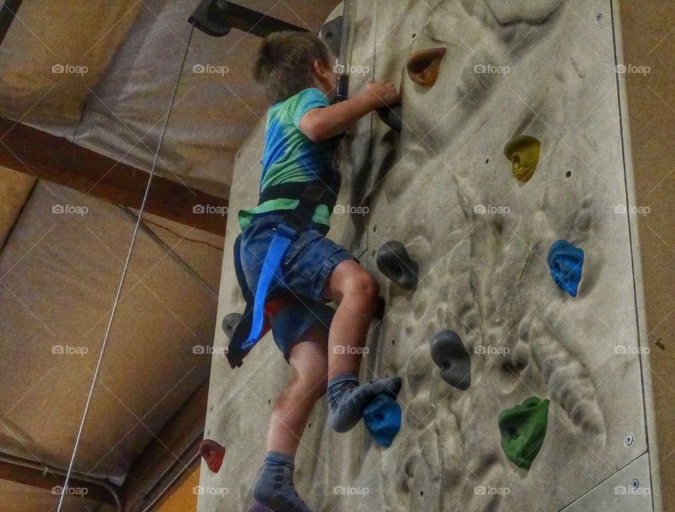 Boy Climbing A Rock Wall