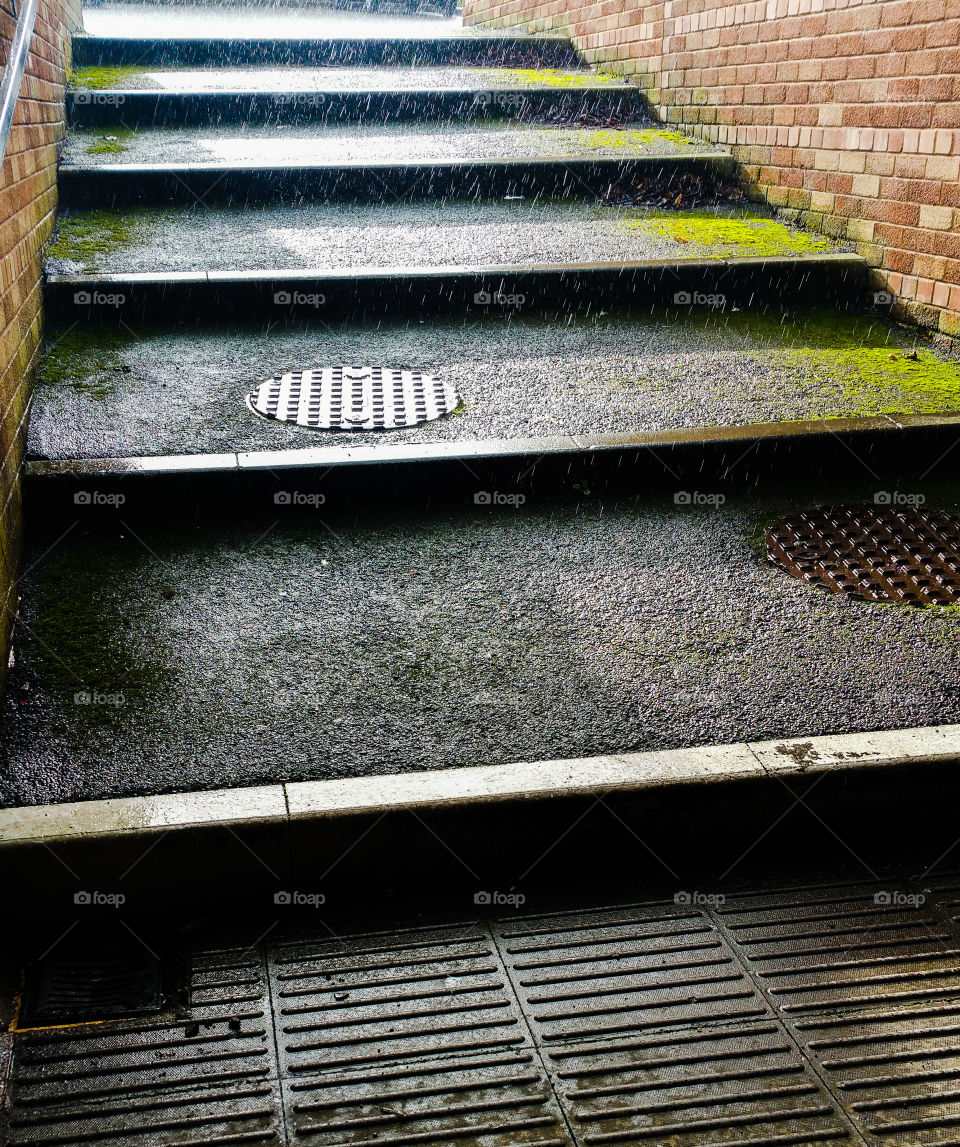 Rain falling over some steps and a pavement