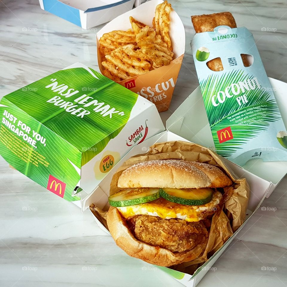 Just for you, Singapore! McDonald's special edition "Nasi Lemak" Burger. Coconut milk flavoured chicken thigh patty coated with cornflake crunch and, paired with a sweet yet spicy sambal sauce, then topped with a fried egg, caramelised onions and crunchy cucumber slices.