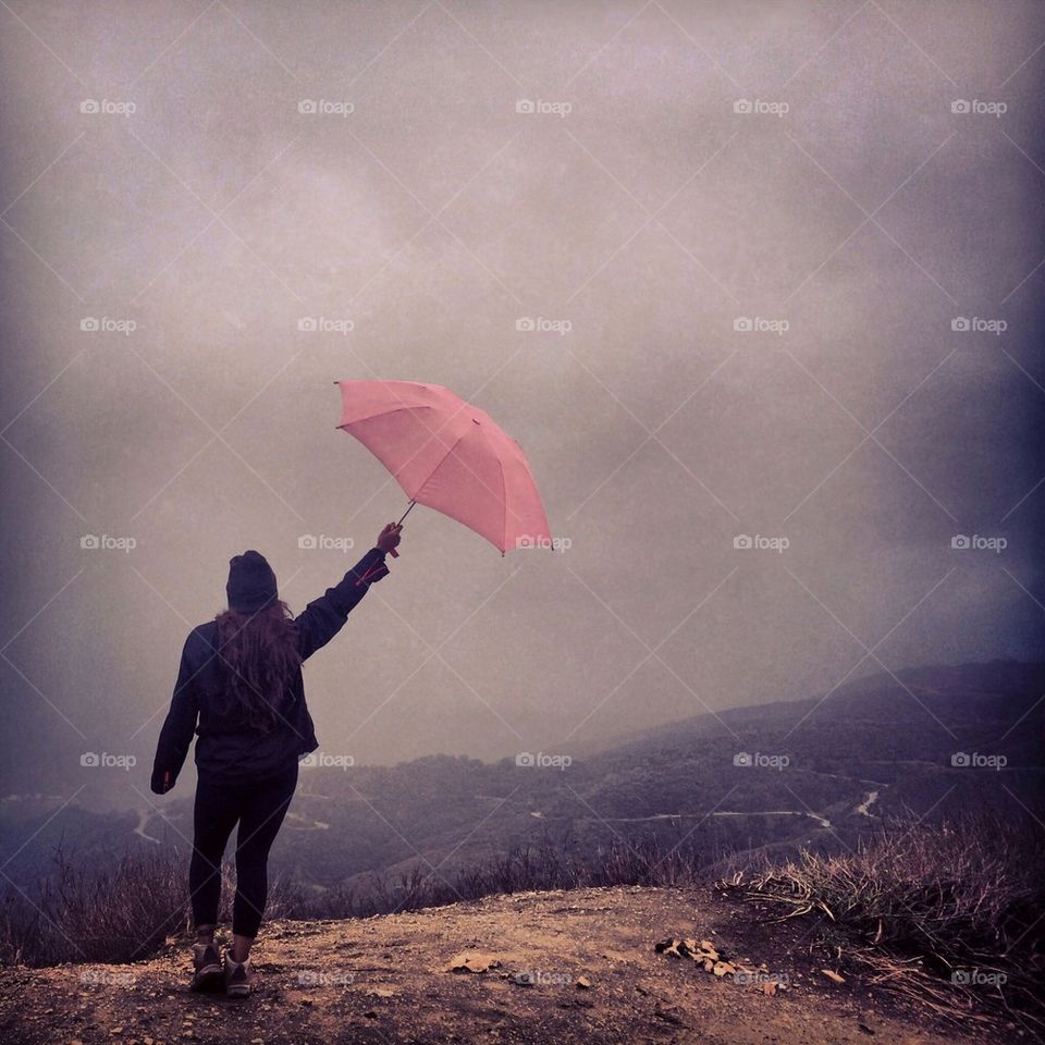 Rear view of woman holding pink umbrella