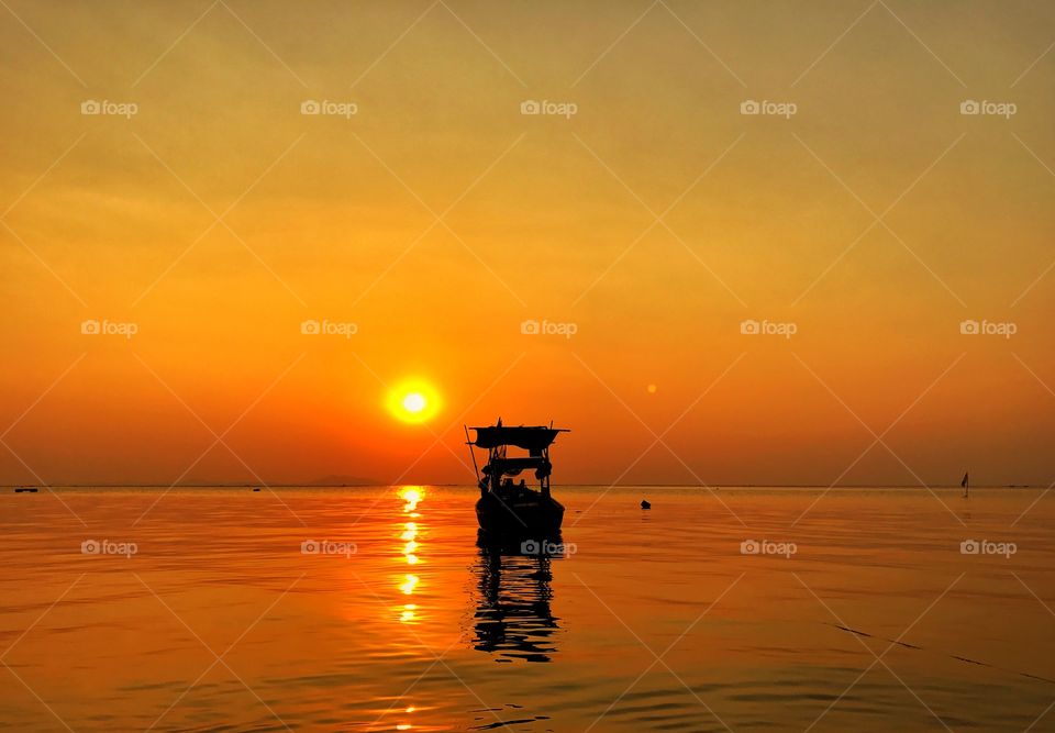 Sunset and orange shade sky with silhouette fisherman on the sea