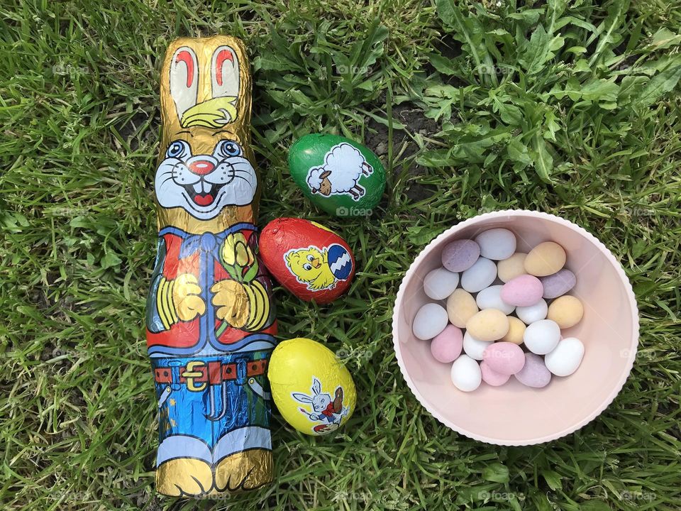 Basket of colorful easter eggs, sweet chocolate eggs, and the chocolate easter bunny