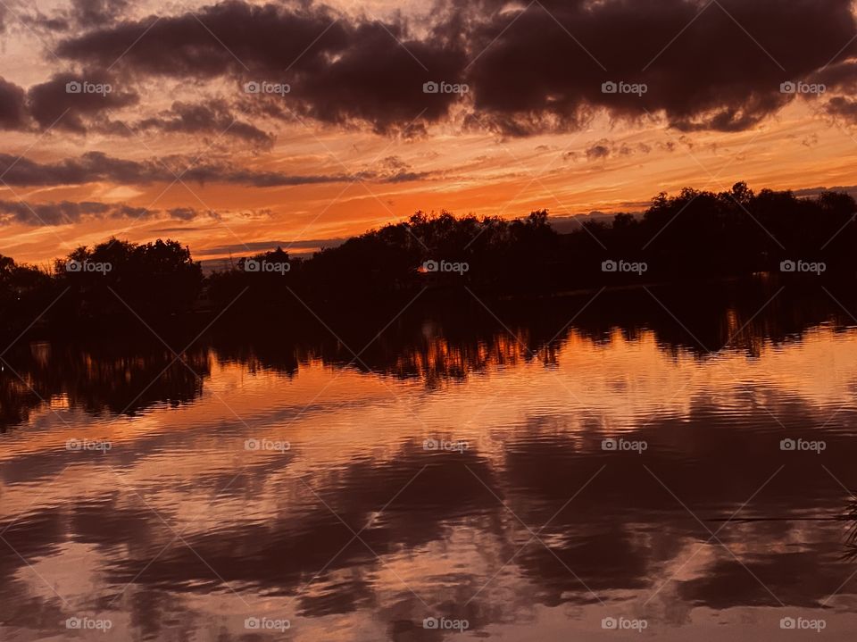 Sundown has completed Twilight in effect dark clouds above lake waters Refections back to lake waters. Colors from Twilight Reflect back to lake waters silhouetted to Double the effect.