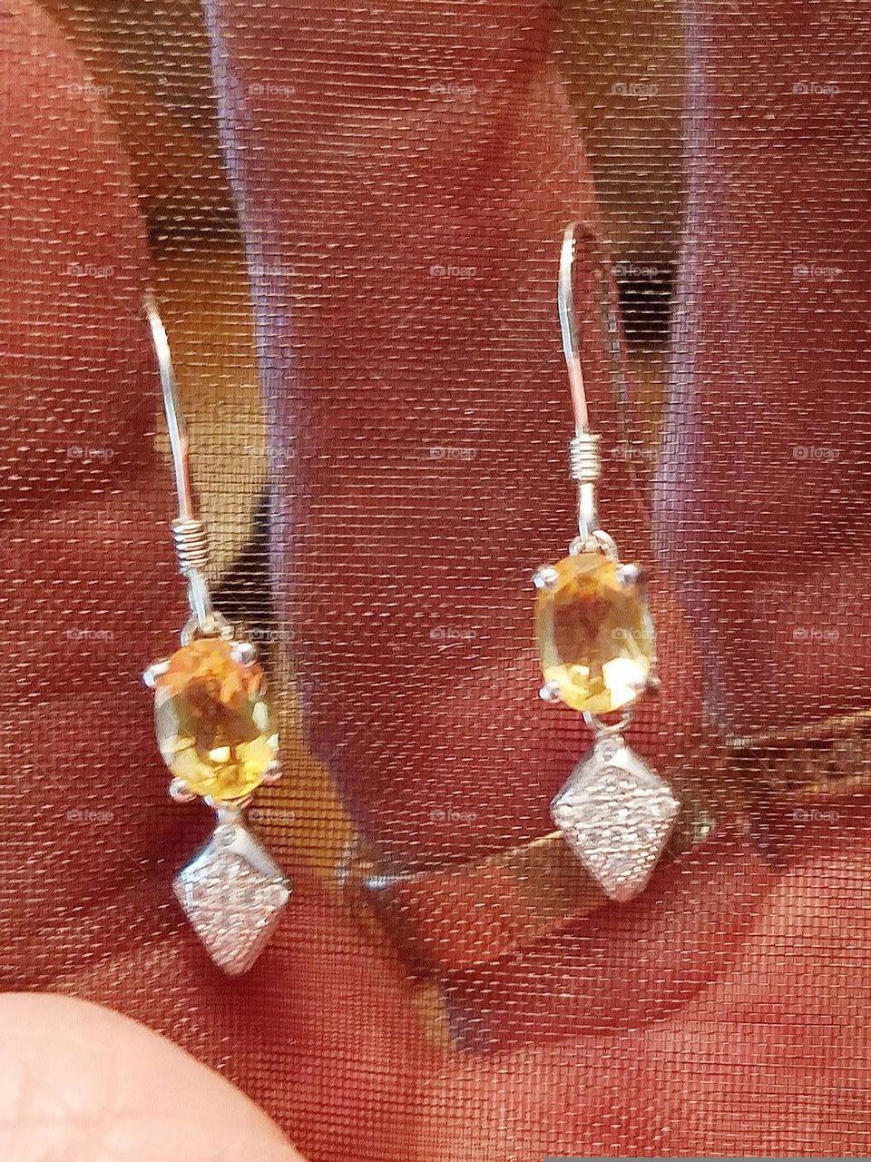 Pic of white gold earrings with amber color stones. These earrings are in a 4 prong setting and are dainty to wear. Womans silver hanging earrings, dangle earrings.