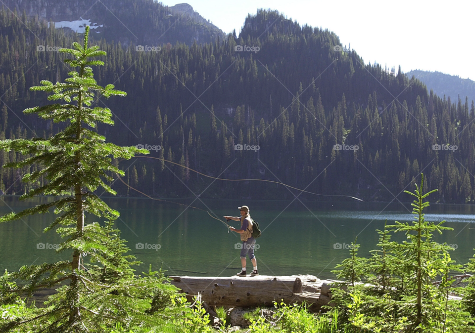 a fly fisherman casts over an alpine lake in montana usa. montana fly fishing. northwestern united states by arizphotog