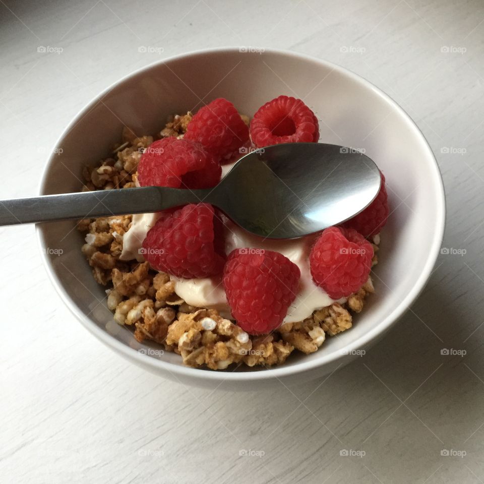 A healthy lunch with raspberries, granola and yogurt always helps the day go by fast