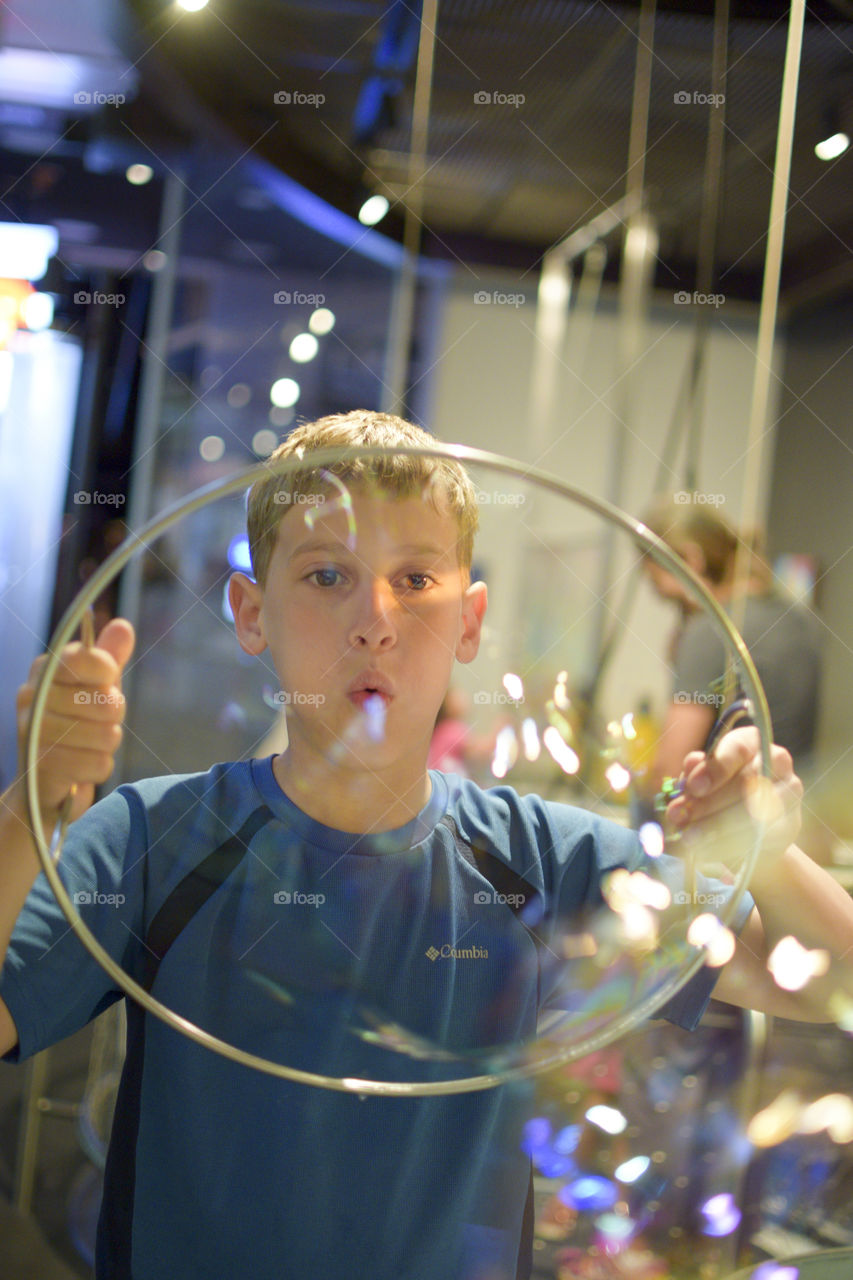 Close-up of a boy blowing soap bubbles