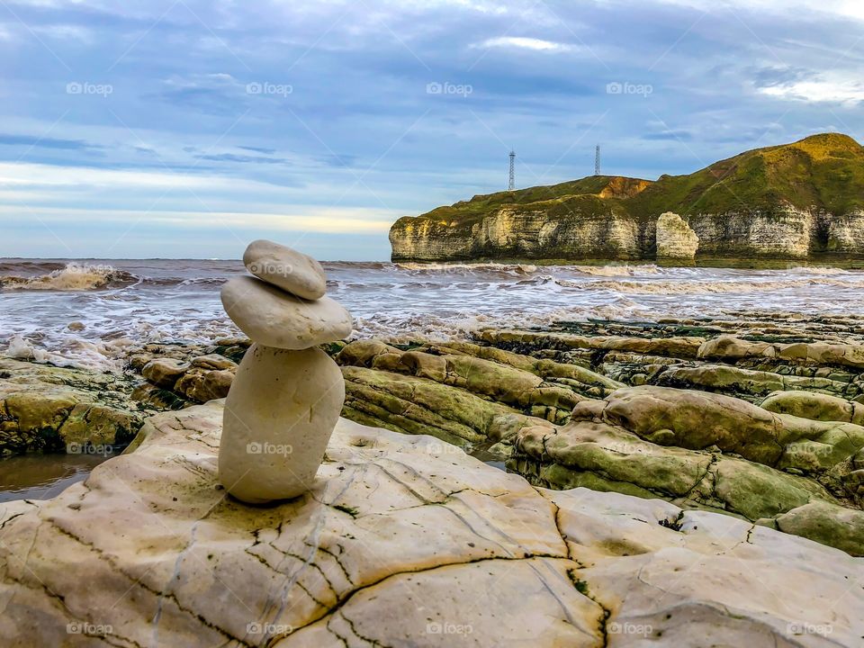 Small rock stack on the coast of the uk surrounded by chalk cliffs. 