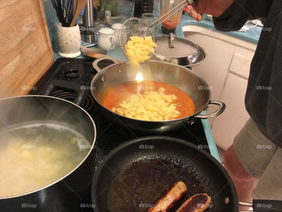 Adding second spoonful of pasta to sauce 