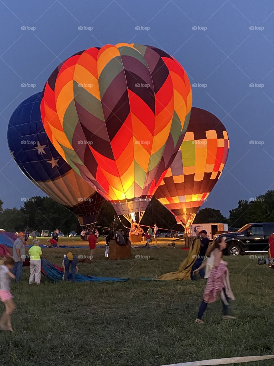 Hot air balloons being inflated in a field.
