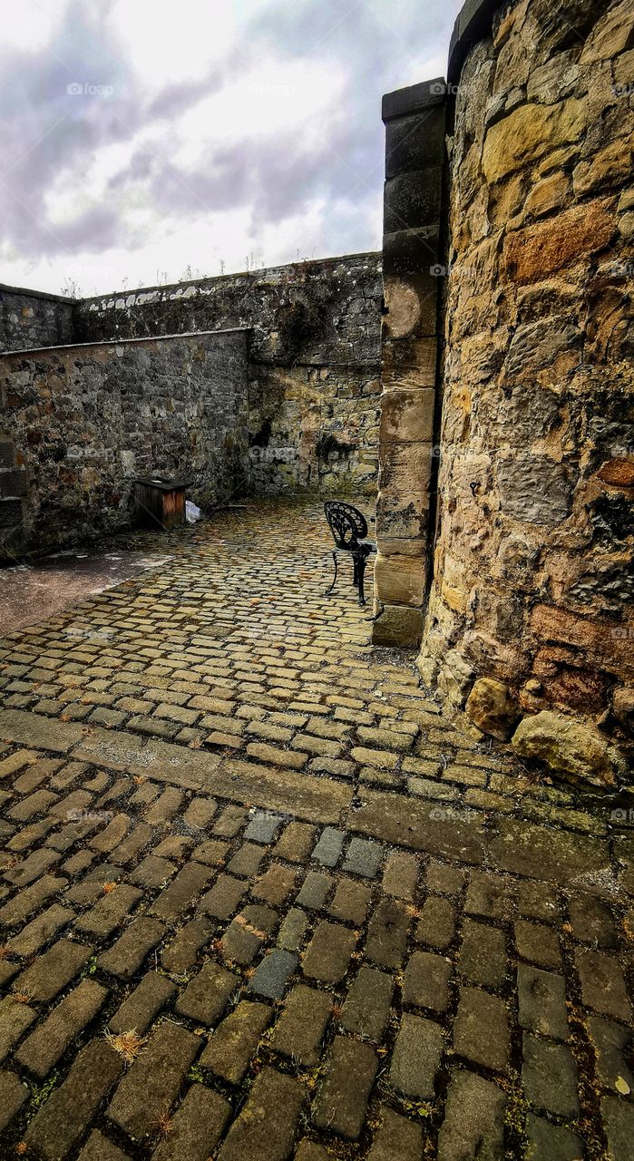 Chair in an old brick courtyard