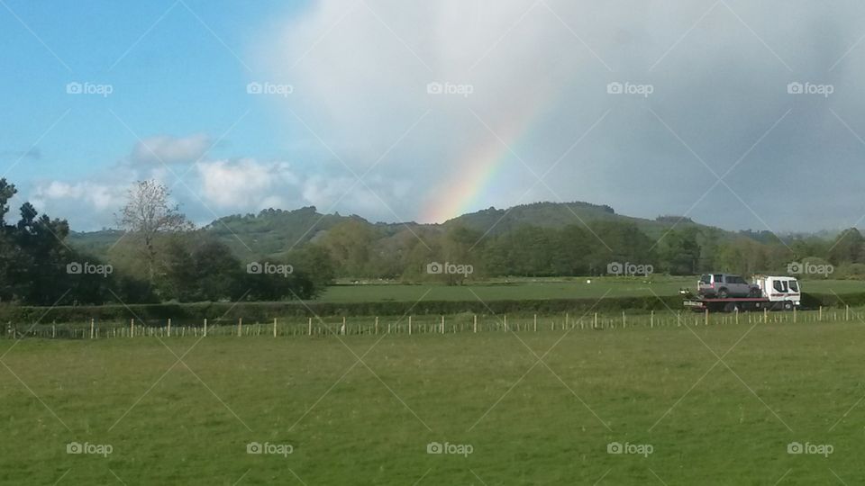 Rainbow coming up from the mountain in Wales