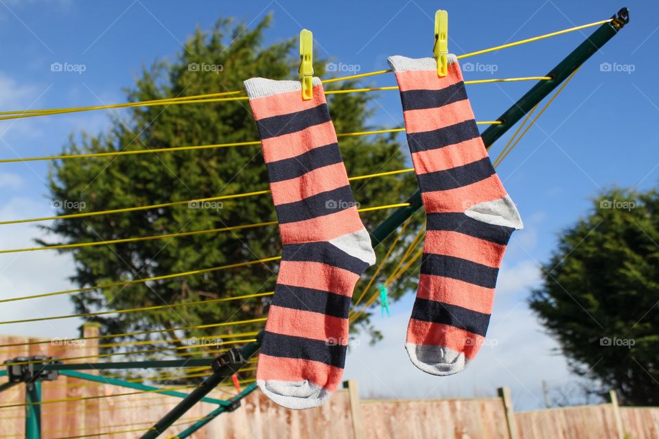 A pair of striped socks hanging on the washing line