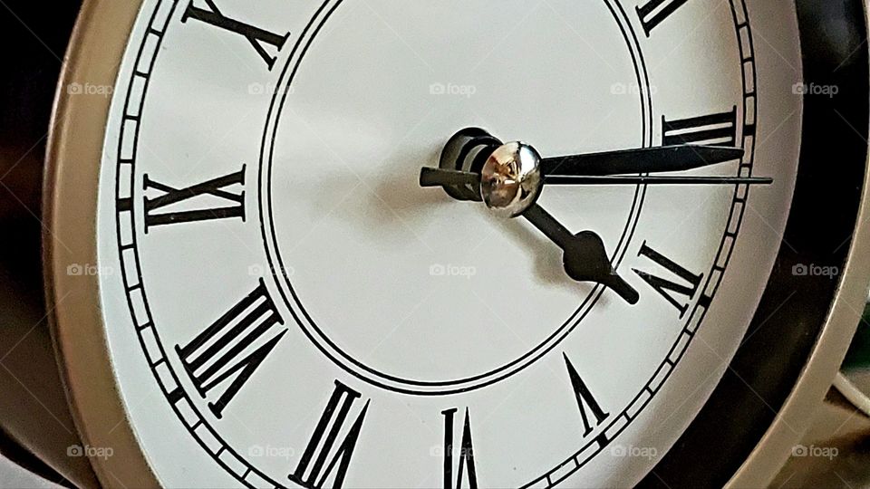 Black Roman numerals on a white clock dial