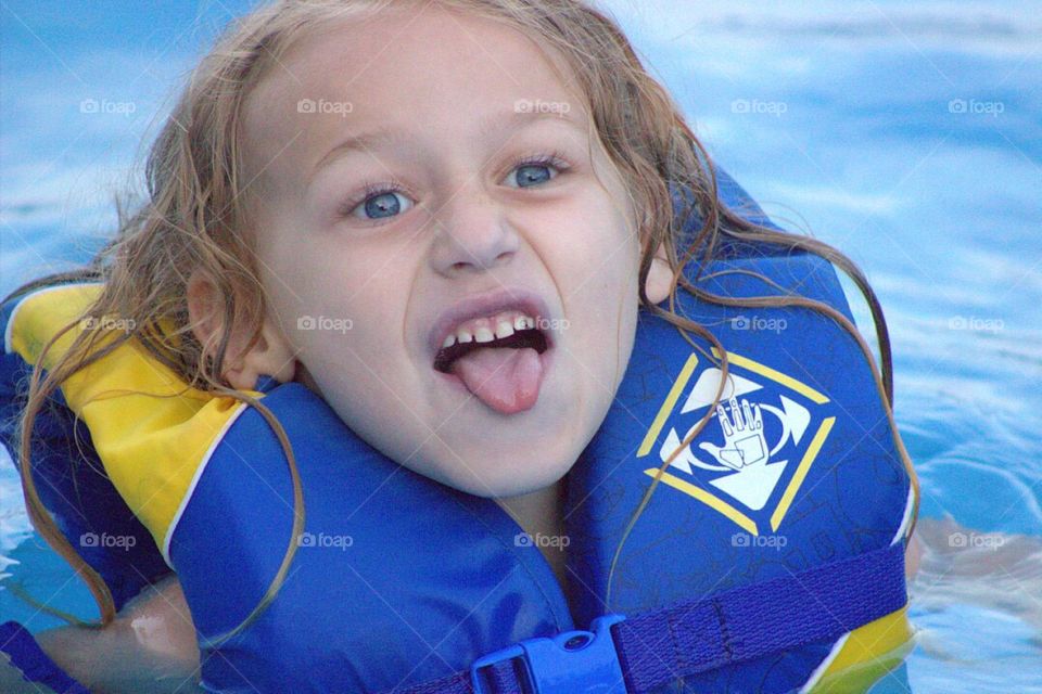 Cute little girl in swimming pool with life jacket