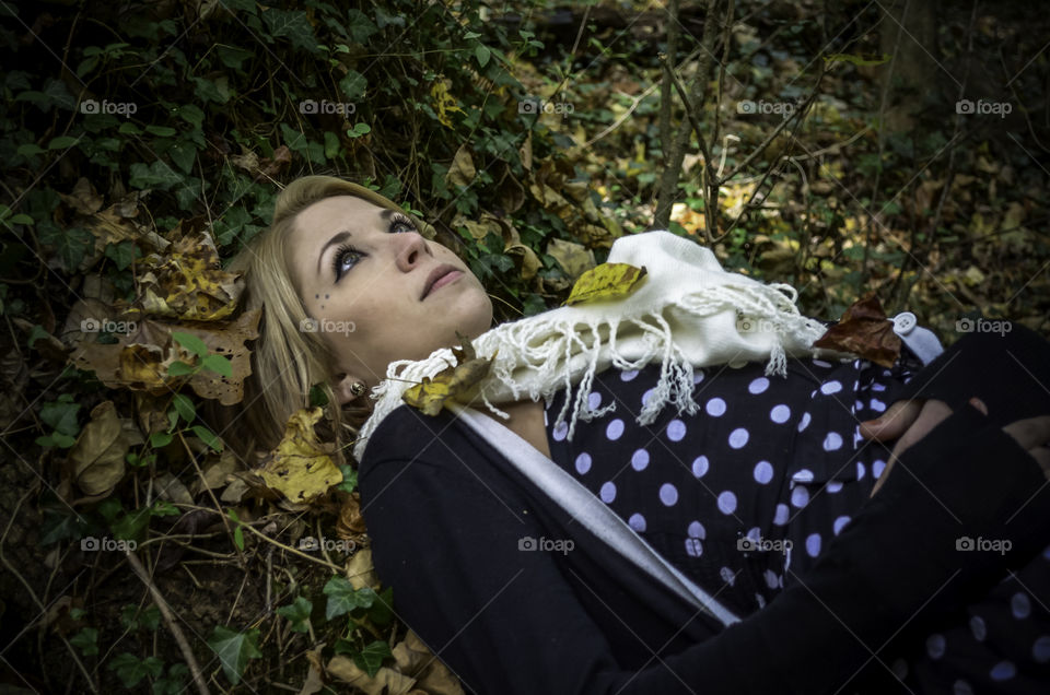 Stylish woman lying in forest