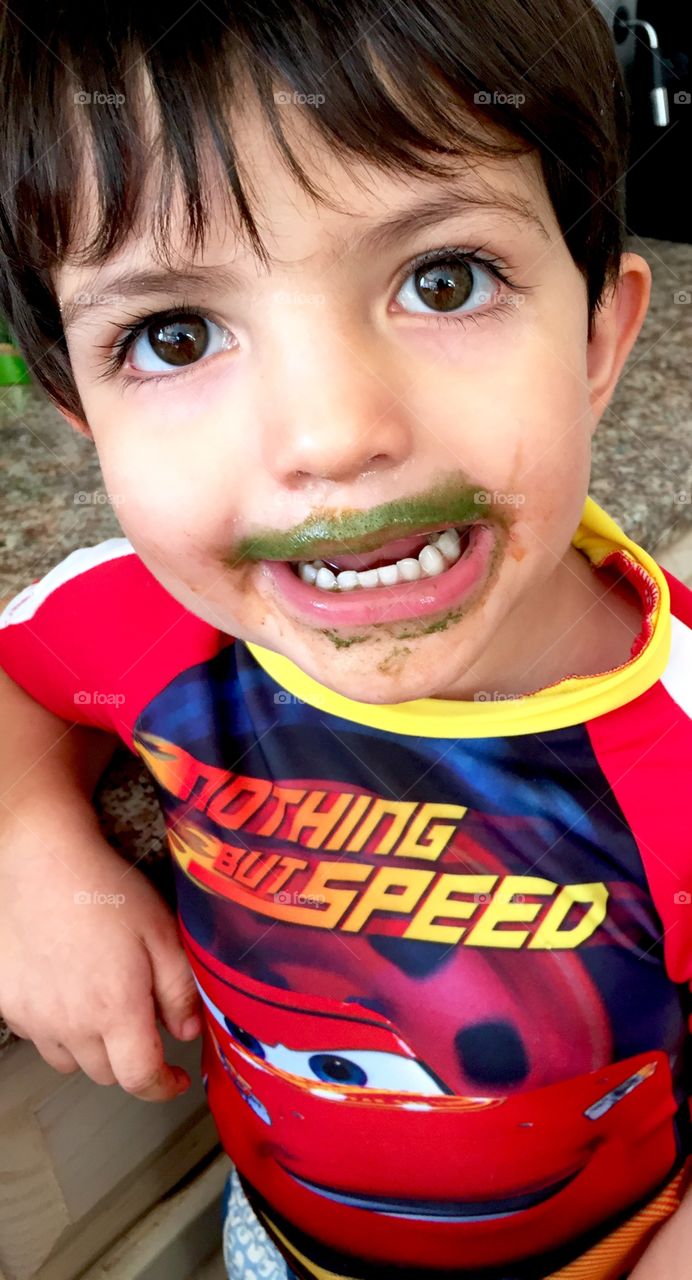 Portrait of little boy with messy face after eating