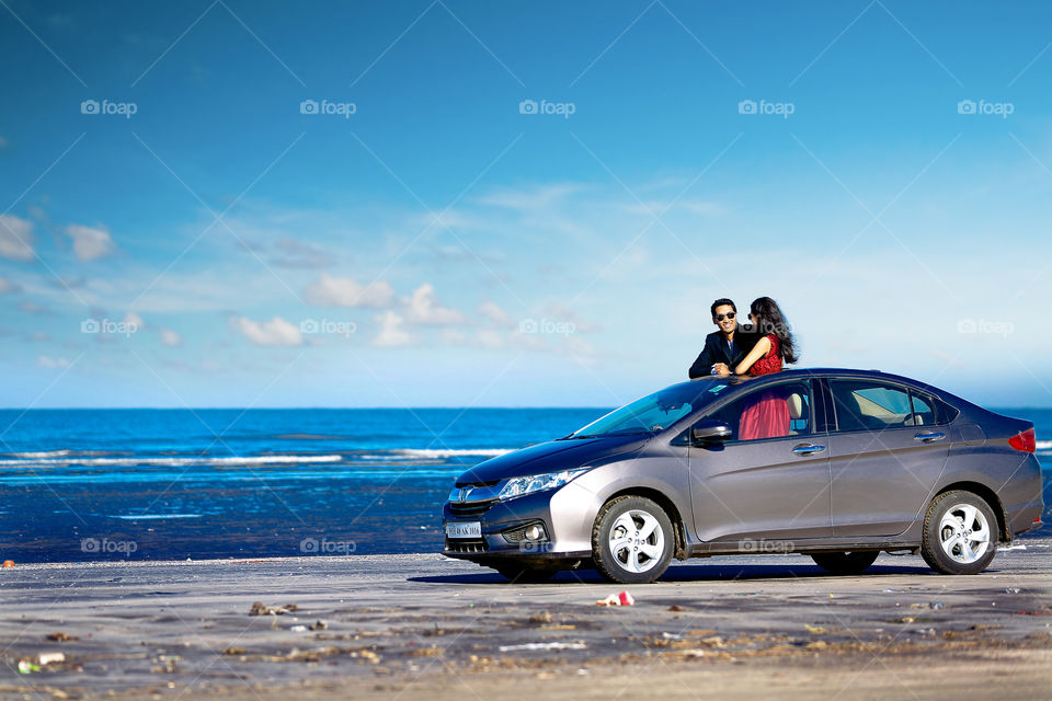 Happy couple in car at beach
