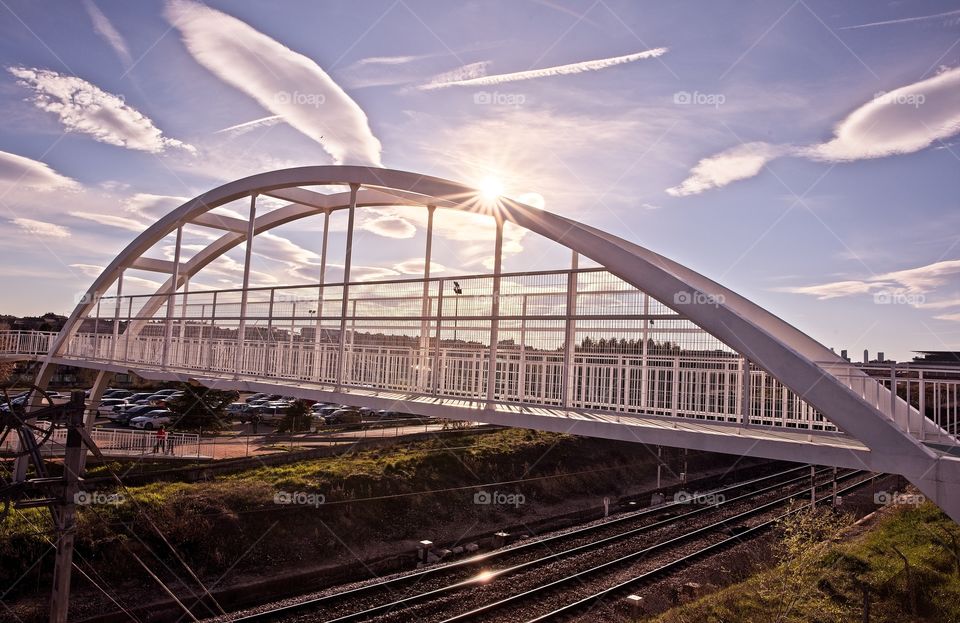 bridge over the train tracks at sunset