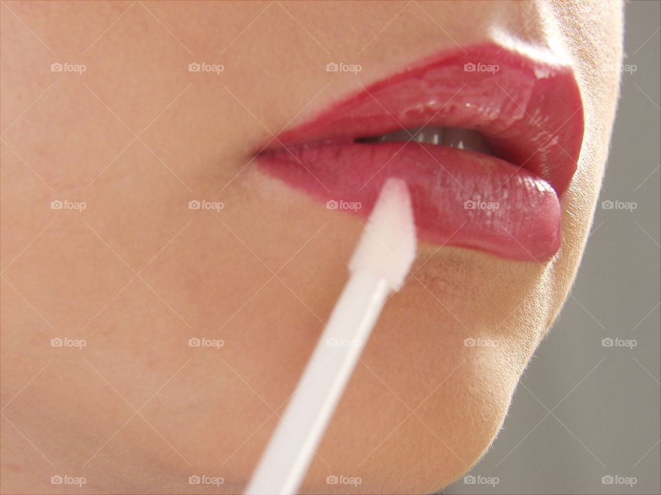 Woman makeup her lips.