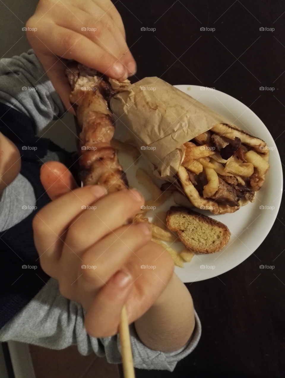 child eating meat stick and pita gyros