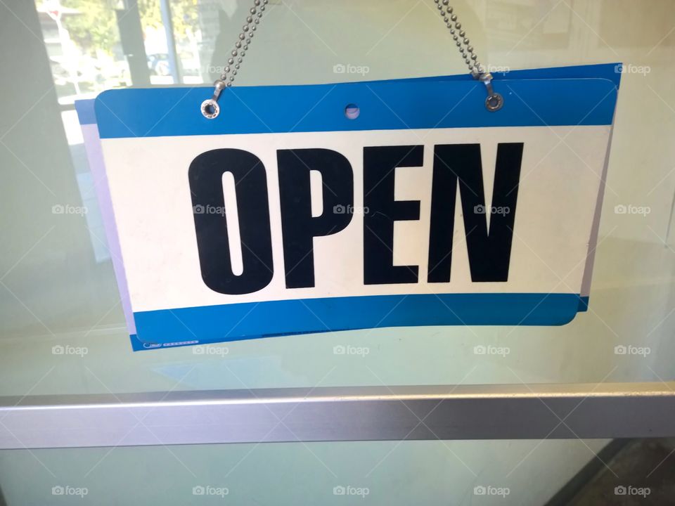 Blue and white open sign, black letters.