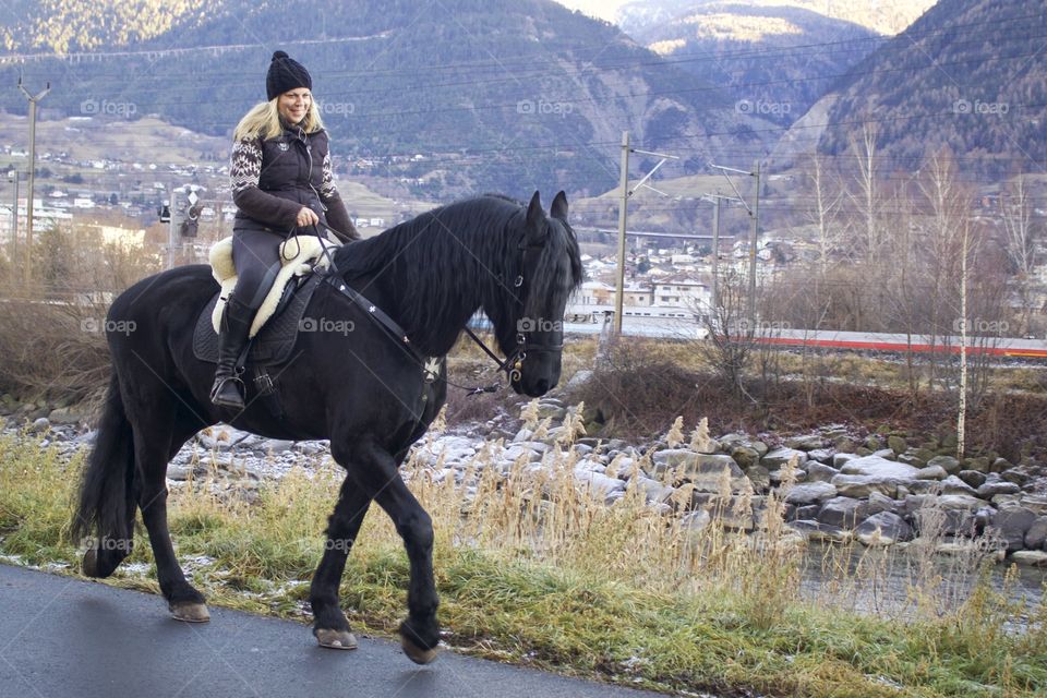 Portrait Of Happy Woman Riding A Friesian Horse In Naters,Wallis