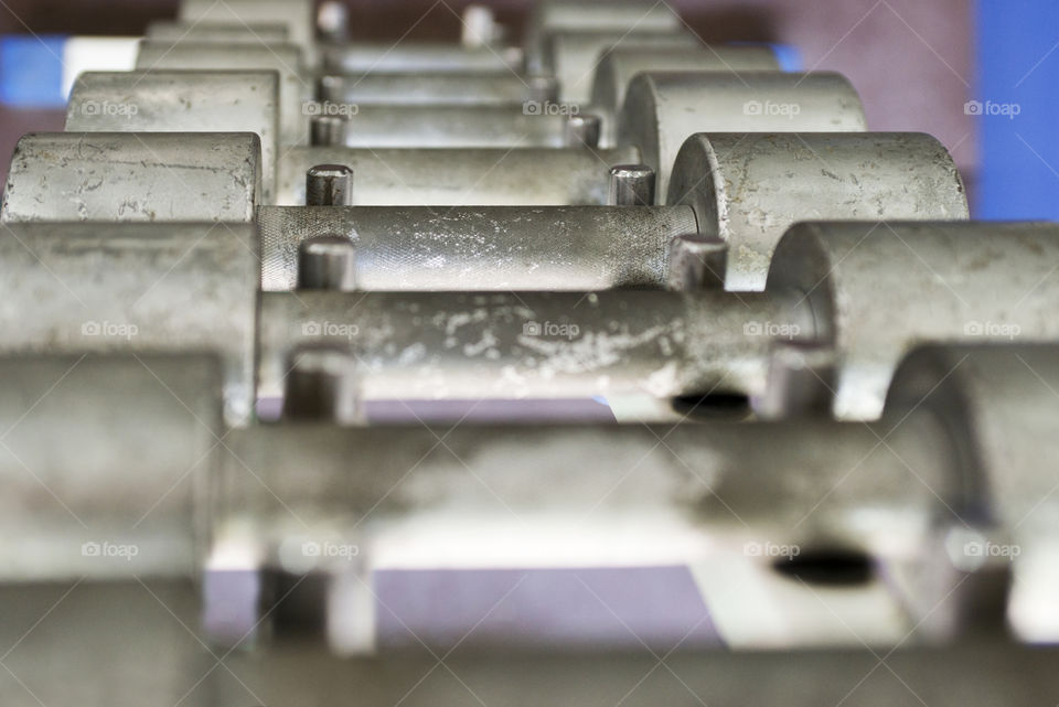 Rows of dumbbells in the gym. Dumbbell set. Close up many metal dumbbells on rack in sport fitness center