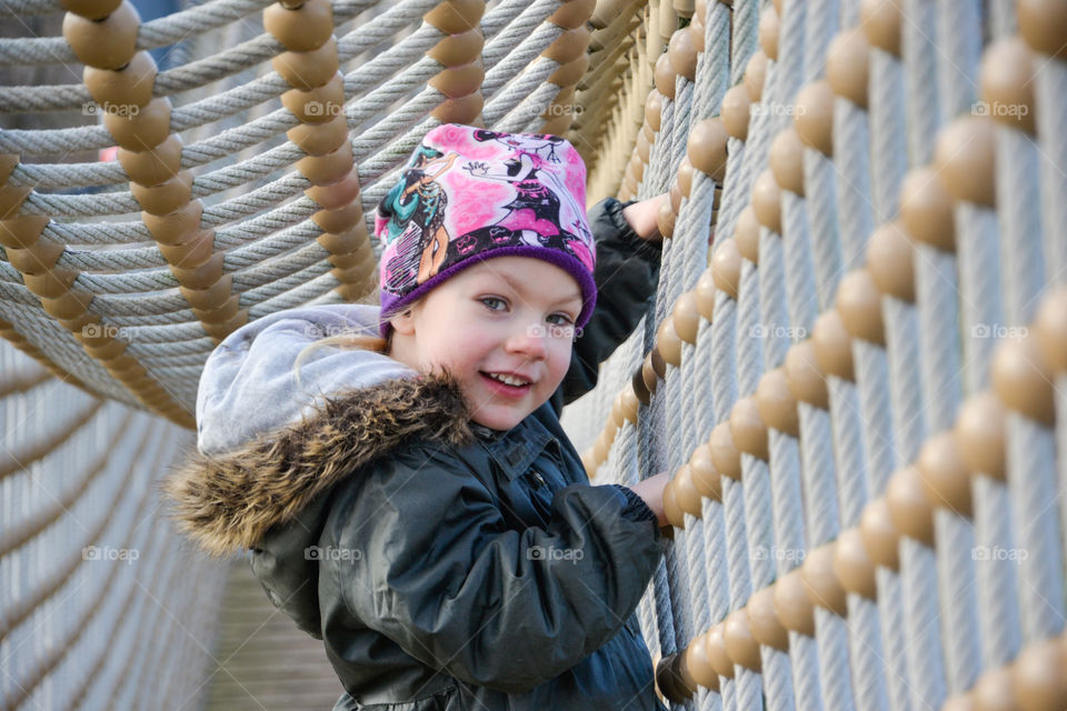 Girl playing on rope bridge
