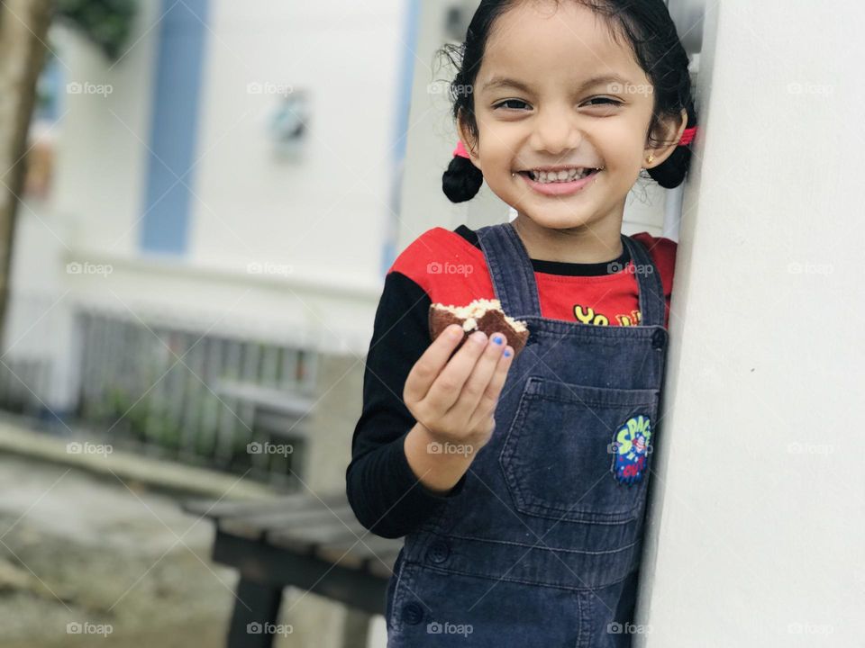 Cheerful smile of baby girl while eating Indian brown cookie ☺️