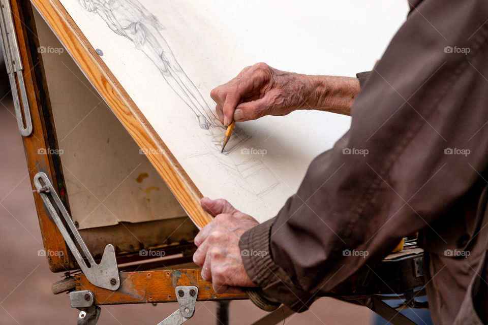 Artist sketching with the pencil, hands in frame