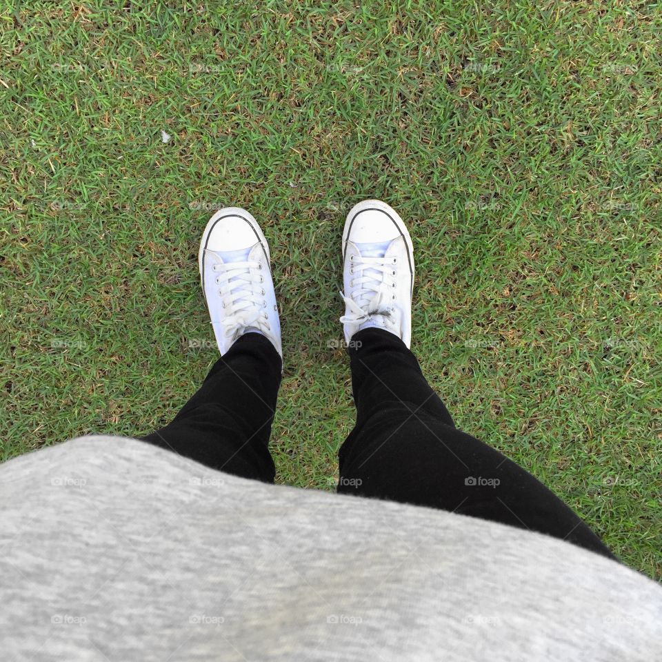 Feet In Sneakers In Green Grass Great For Any Use.