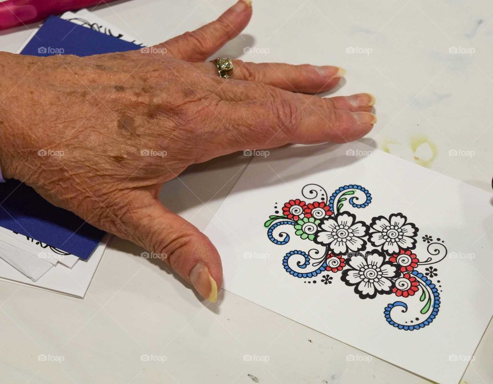 Woman's hand coloring a design