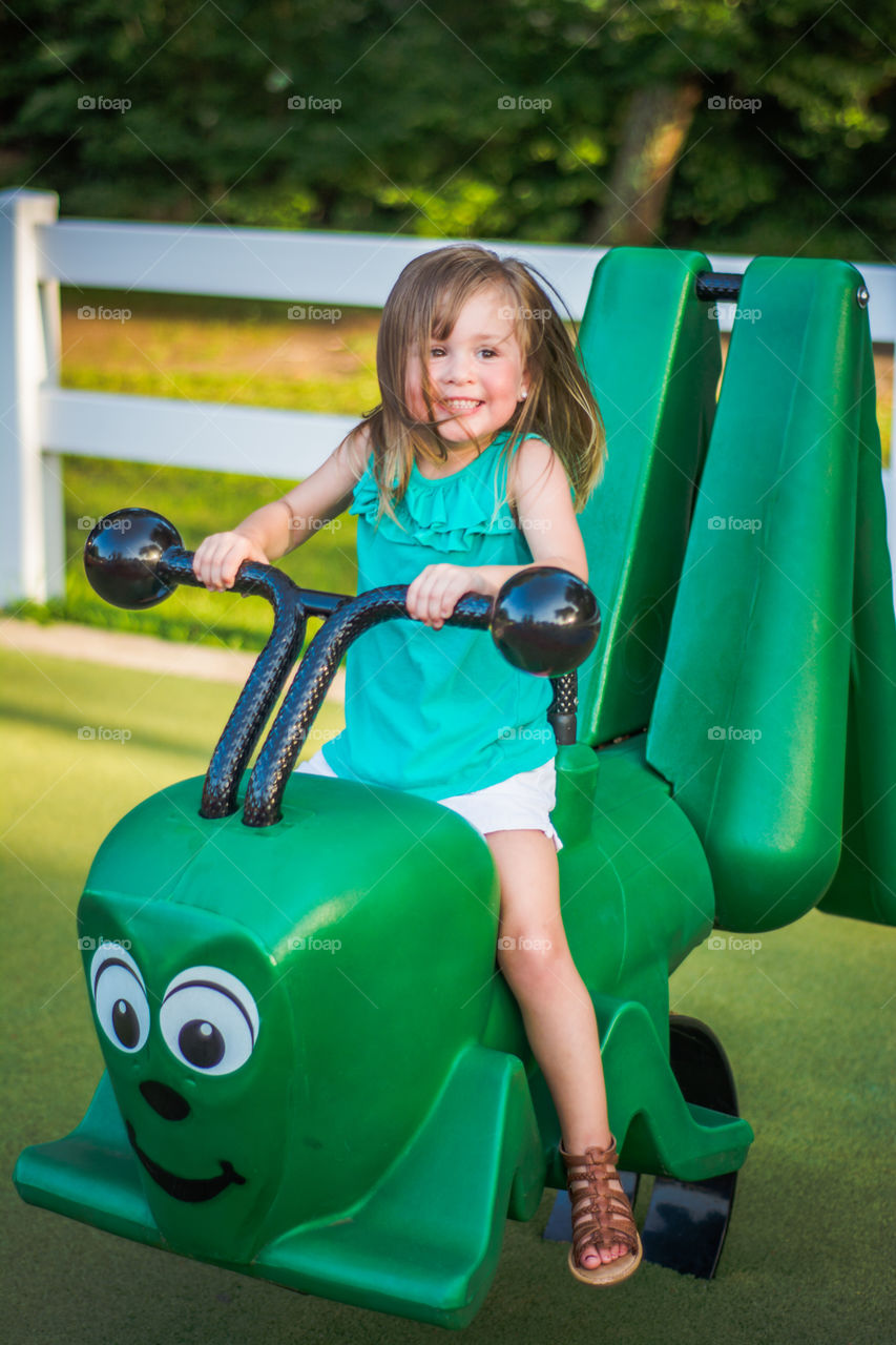 Young Girl on Green Caterpillar at the Playground 3